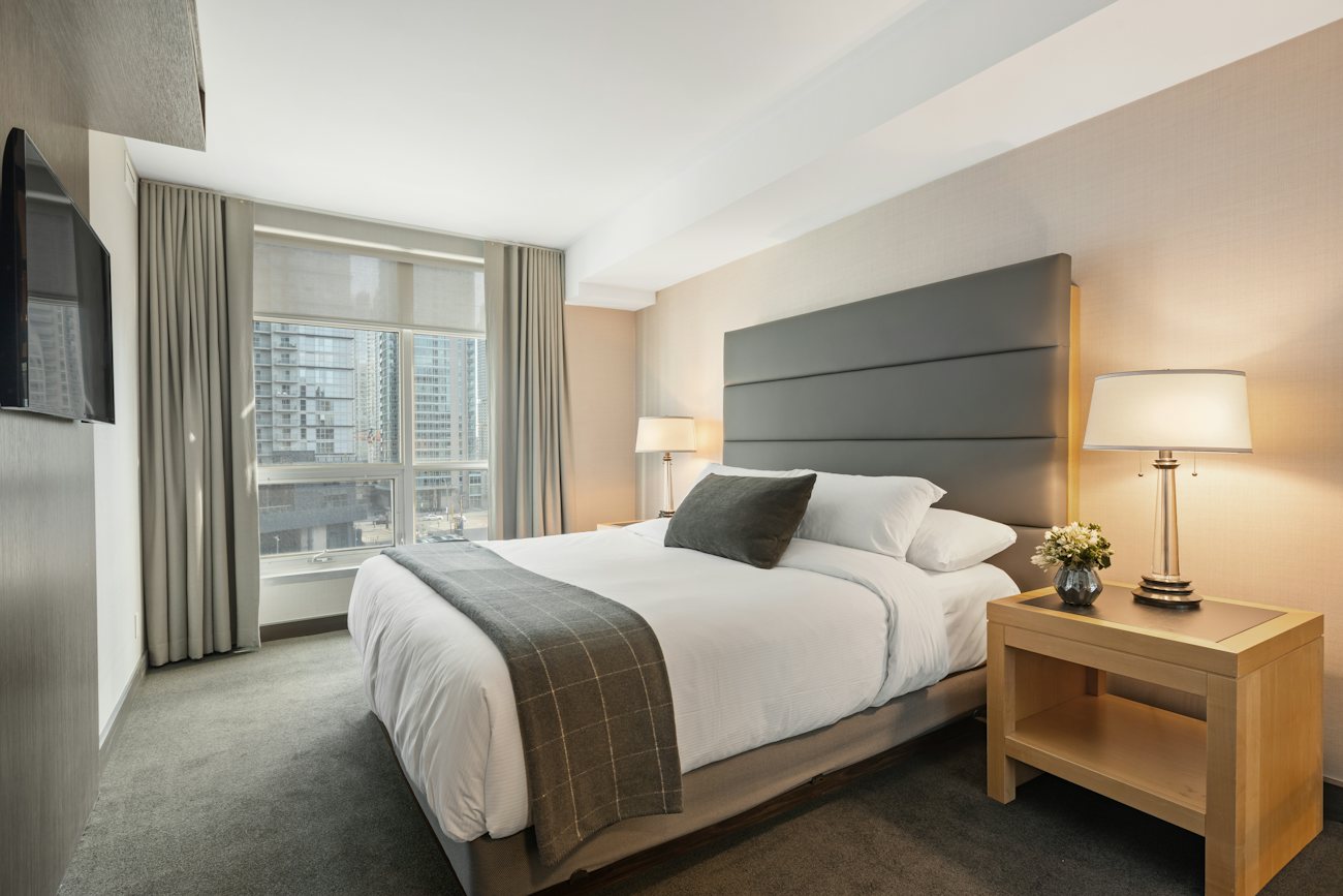 Bright executive room with a made bed and desk